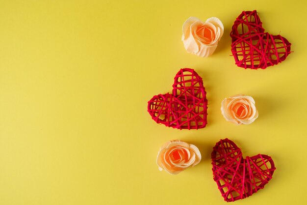 Cuori rossi e fiori su sfondo giallo, cartolina di design per San Valentino. Posto per il tuo testo.