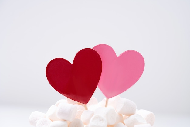 Cuori rossi e rosa in marshmallow sul muro bianco. Concetto di San Valentino. Avvicinamento
