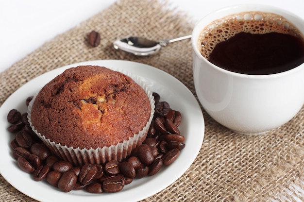 Cupcake al cioccolato e tazza di caffè caldo su tela