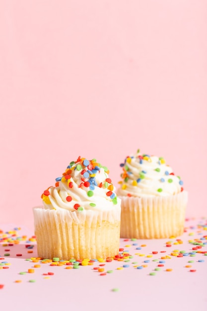 Cupcake alla crema bianca con spruzzi di colore su foto di alta qualità rosa rose