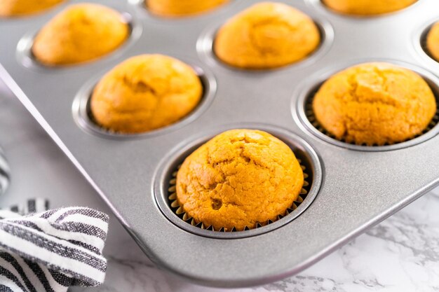 Cupcake alle spezie di zucca appena sfornato che si raffredda in una teglia.