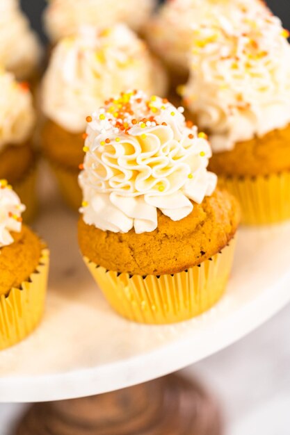 Cupcake alle spezie di zucca con crema al burro italiana e spruzza su un'alzatina.