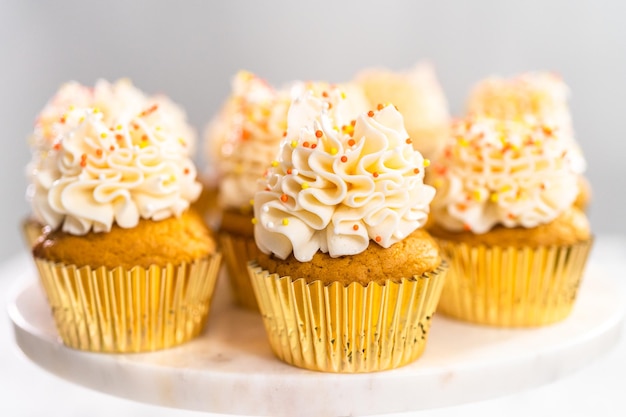 Cupcake alle spezie di zucca con crema al burro italiana e spruzza su un'alzatina.