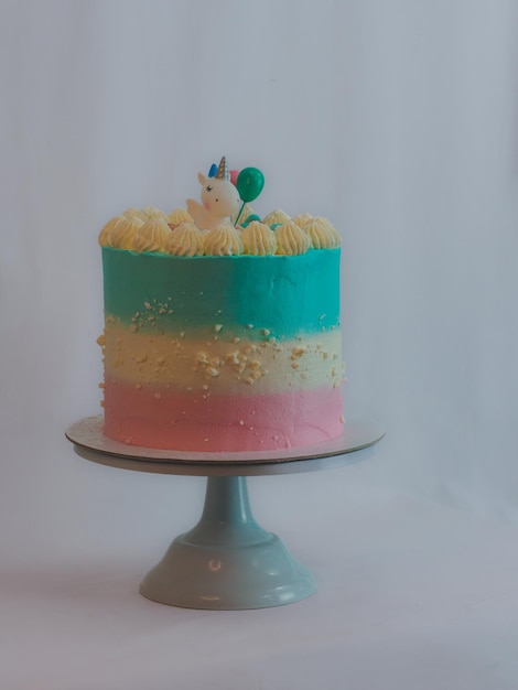 Cupcake blu rosa glassato con granelli di meringa e topping di unicorno