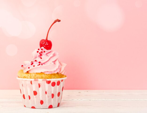 Cupcake con crema rosa e ciliegia