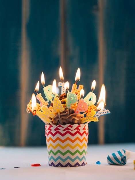 Cupcake con illuminazione Happy Birthday candele sul blu