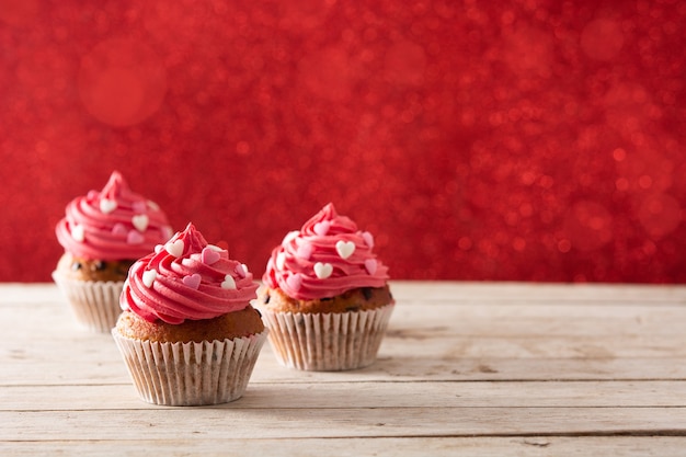 Cupcake decorato con cuori di zucchero e una freccia di Cupido per San Valentino sulla tavola di legno