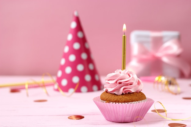 Cupcake delizioso con una candela su uno sfondo colorato con spazio per inserire il testo. Sfondo festivo, compleanno. Foto di alta qualità