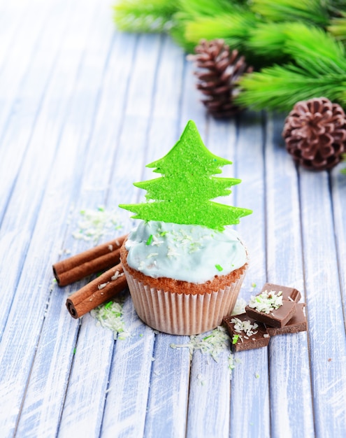 Cupcake gustoso con crema al burro, su tavola in legno colorato