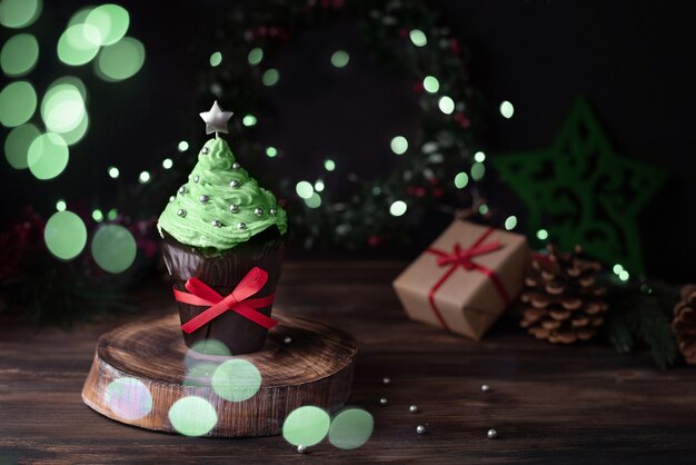 Cupcake natalizio a forma di albero di Natale con luci bokeh muffin con decorazioni festive