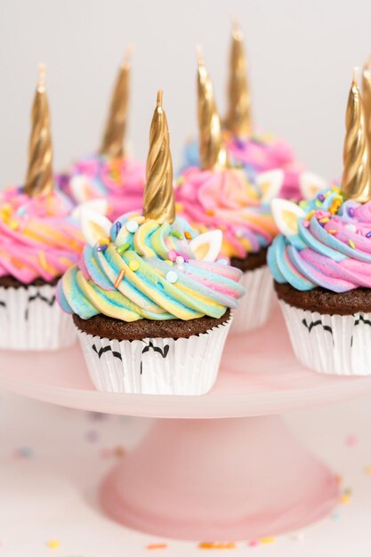 Cupcakes a forma di unicorno decorati con glassa di crema al burro colorata e confettini.