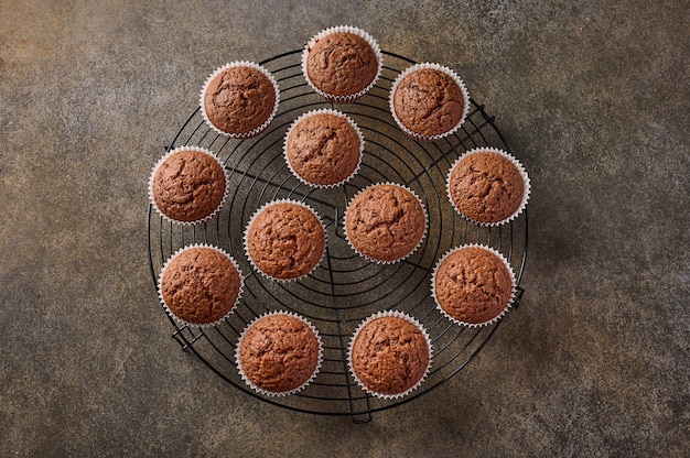 Cupcakes al cioccolato fatti in casa su una griglia stare su una superficie di legno, vista dall'alto