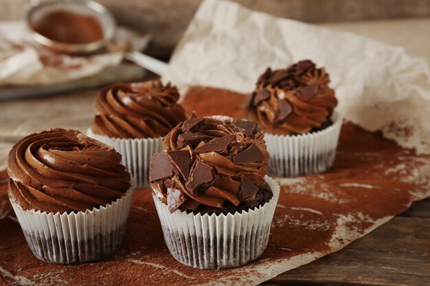 Cupcakes al cioccolato su carta da forno su fondo in legno