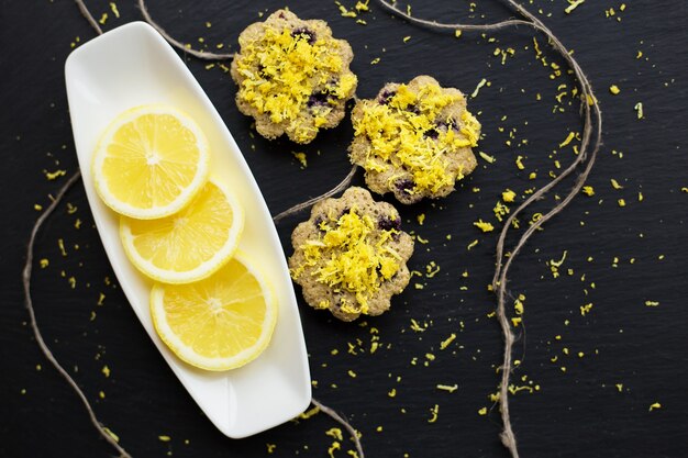 Cupcakes al limone su sfondo nero con buccia di limone