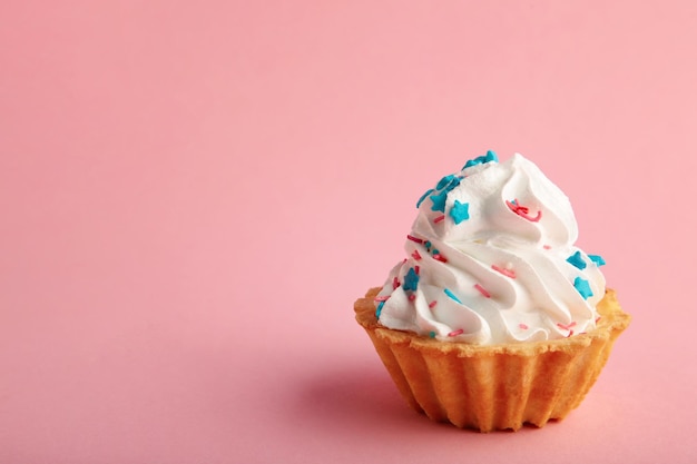 Cupcakes alla vaniglia decorati con spolverata su sfondo rosa con spazio per la copia