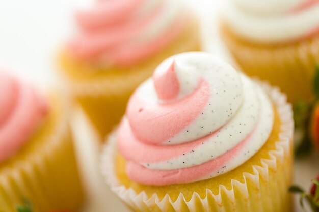 Cupcakes alla vaniglia guarniti con crema di fragole.