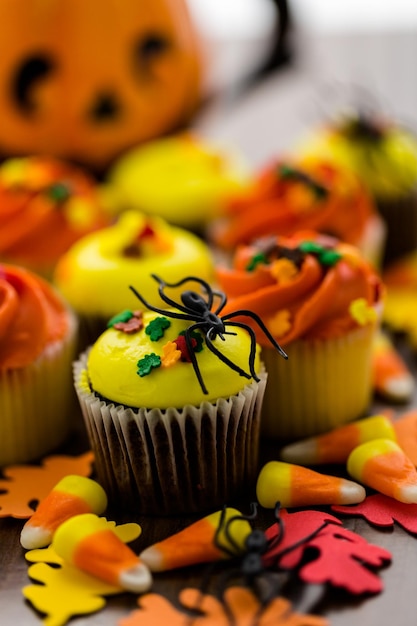 Cupcakes assortiti con glassa gialla e arancione decorati per l'autunno.