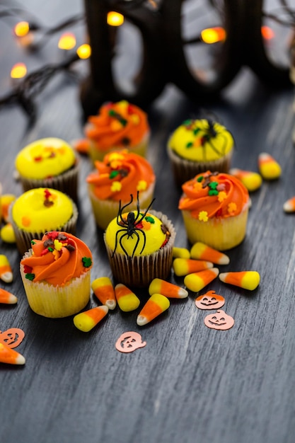 Cupcakes assortiti con glassa gialla e arancione decorati per l'autunno.