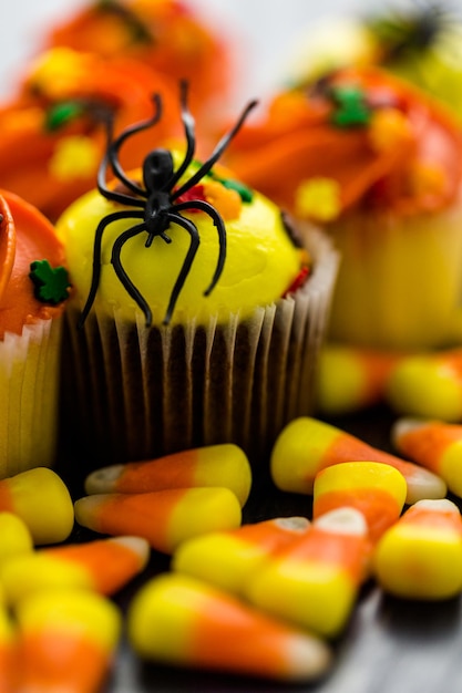 Cupcakes assortiti con glassa gialla e arancione decorati per l'autunno.