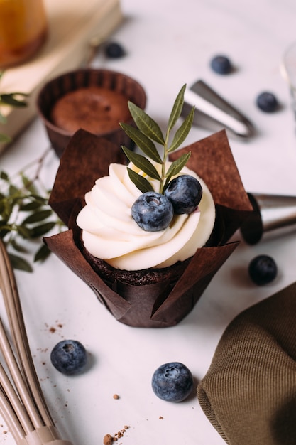 Cupcakes con crema e mirtilli sul tavolo della cucina