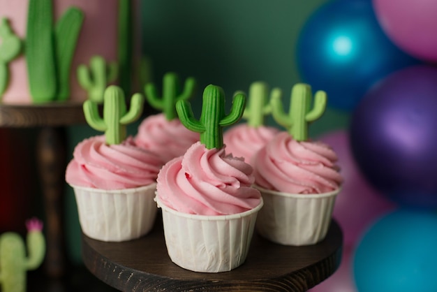 Cupcakes con crema rosa decorati con cactus. Tavola di compleanno dolce estiva.
