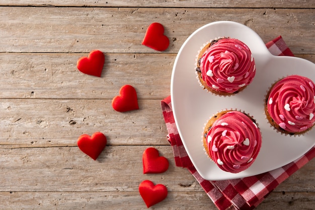 Cupcakes decorati con cuori di zucchero per San Valentino sulla tavola di legno