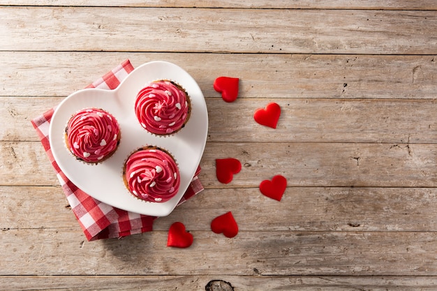 Cupcakes decorati con cuori di zucchero per San Valentino sulla tavola di legno