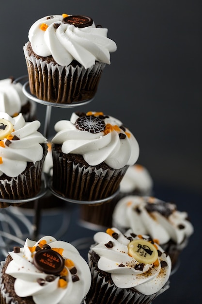 Cupcakes di Halloween al cioccolato con glassa bianca al burro e scaglie di cioccolato sopra.