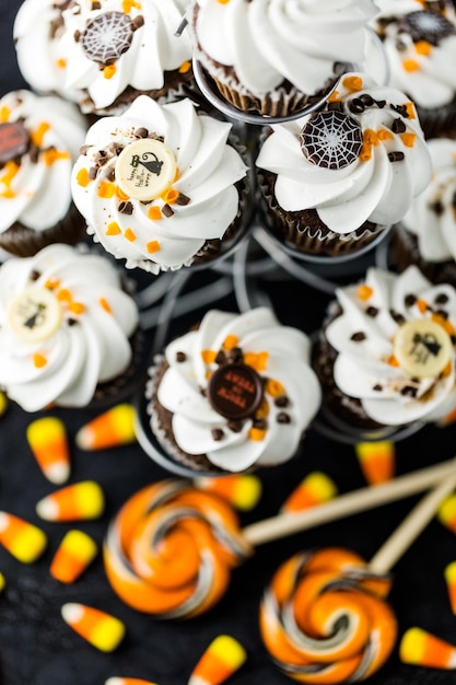 Cupcakes di Halloween al cioccolato con glassa bianca al burro e scaglie di cioccolato sopra.
