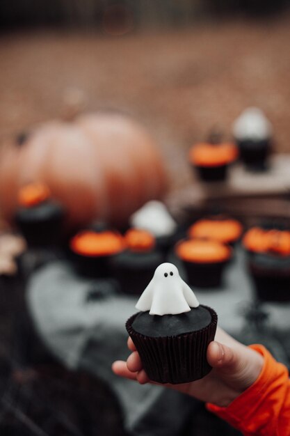 Cupcakes di Halloween e decorazioni per le vacanze a foglie d'acero tra gli alberi nella stagione autunnale all'aperto