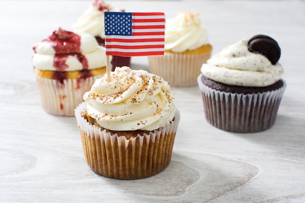 Cupcakes di sapori diversi su un tavolo di legno bianco