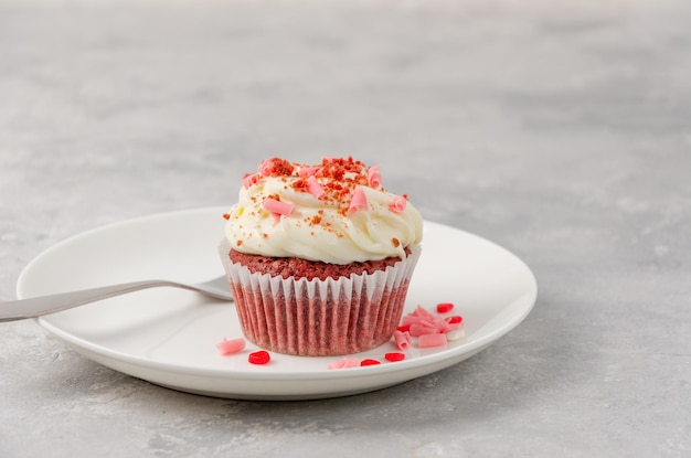 Cupcakes di velluto rosso con glassa di formaggio cremoso sono decorati per lo spazio della copia di San Valentino