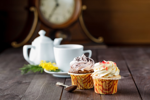 Cupcakes e tazza di tè su fondo di legno scuro