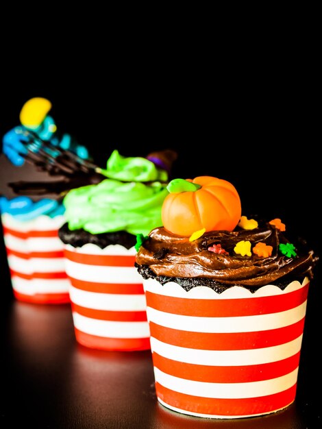 Cupcakes gourmet di Halloween con sfondo nero di decorazioni per le vacanze.