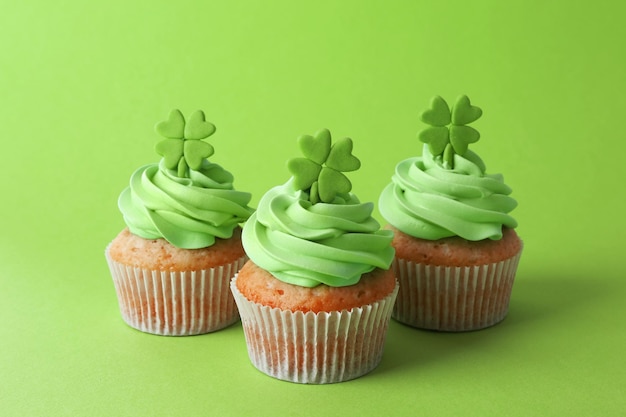 Cupcakes gustosi con trifoglio su sfondo verde Concetto del giorno di San Patrizio