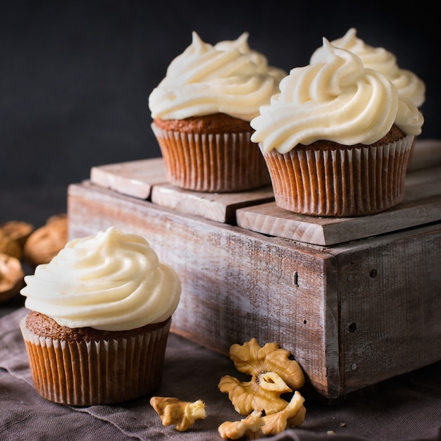 Cupcakes o muffin della carota con i dadi sul nero