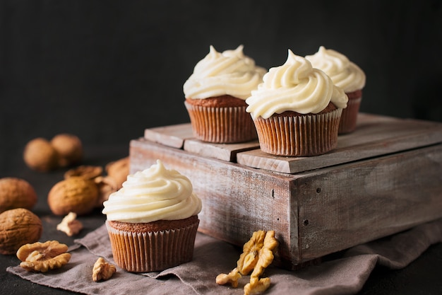 Cupcakes o muffin della carota con i dadi sul nero