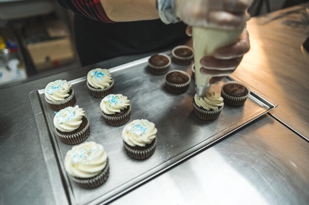 Cupcakes posizionati su una teglia da forno decorati con crema bianca sei cupcakes decorati con crema