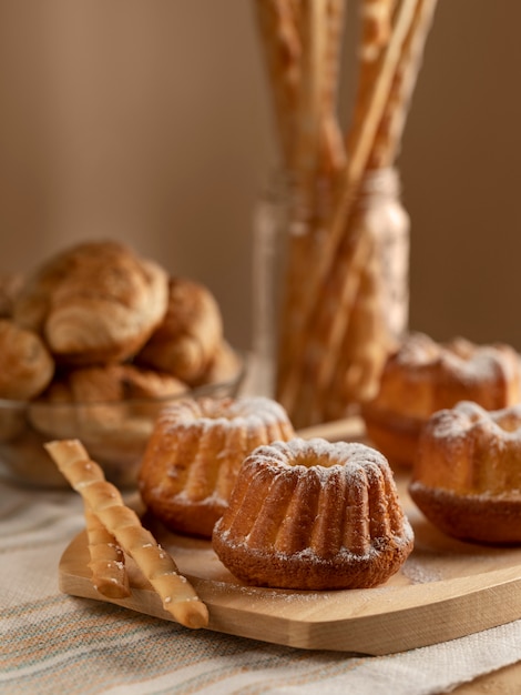 Cupcakes su una tavola di legno in primo piano. Cornetti e grissini