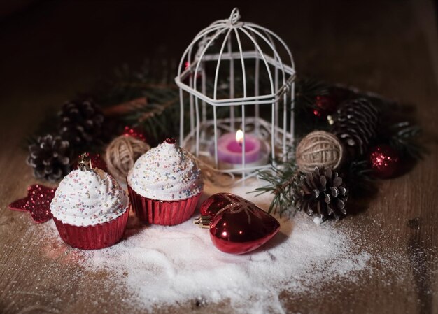 Cupcakescandele natalizie e decorazioni natalizie su fondo in legno