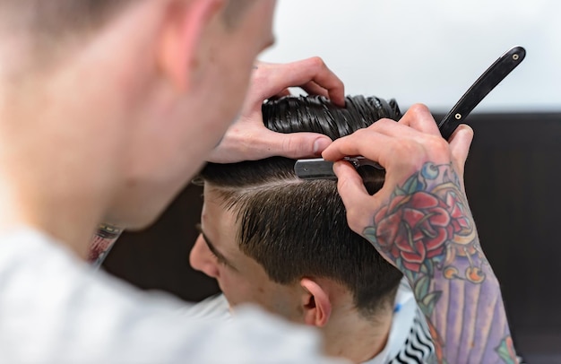 Cura dei capelli degli uomini. Taglio di capelli dal barbiere. Il barbiere fa una bella acconciatura per il cliente.