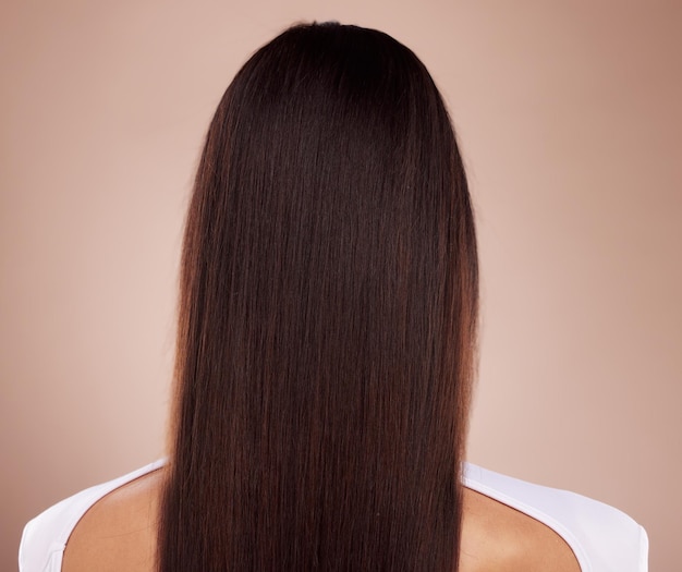 Cura dei capelli di bellezza e schiena della donna in studio isolato su uno sfondo marrone Acconciatura Balayage e modello femminile con capelli lunghi sani e belli dopo il trattamento del salone per consistenza e crescita