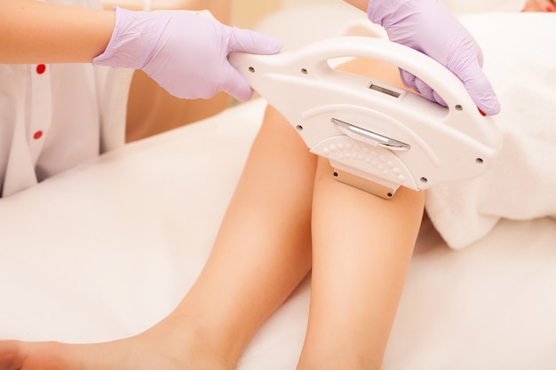 Cura della pelle. Depilazione sulle gambe, procedura laser presso la clinica.