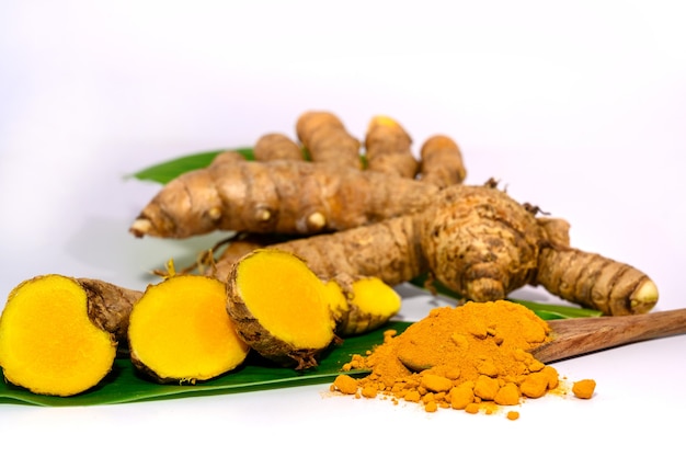 Curcuma e polvere di curcuma Radice di curcuma a fette con foglie verdi isolate su sfondo bianco close-up