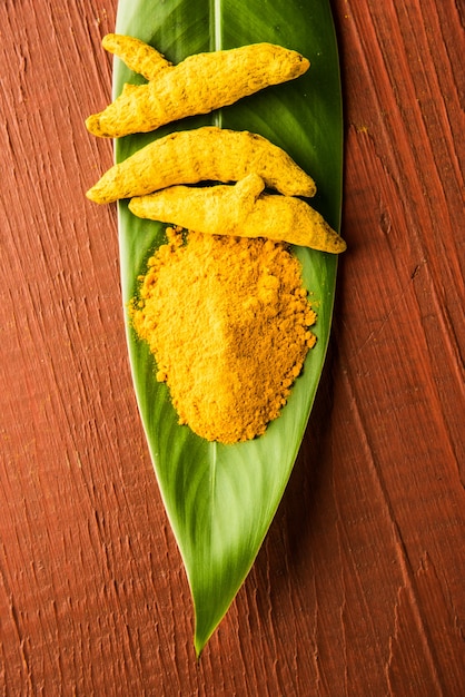 Curcuma intera e mucchio di polvere di haldi o huldi