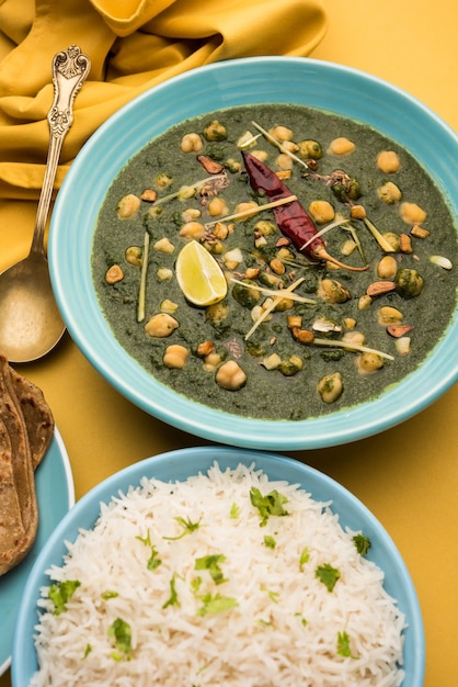 Curry di spinaci di ceci o Chana Masala con Palak servito con riso e focaccia o Paratha, fuoco selettivo
