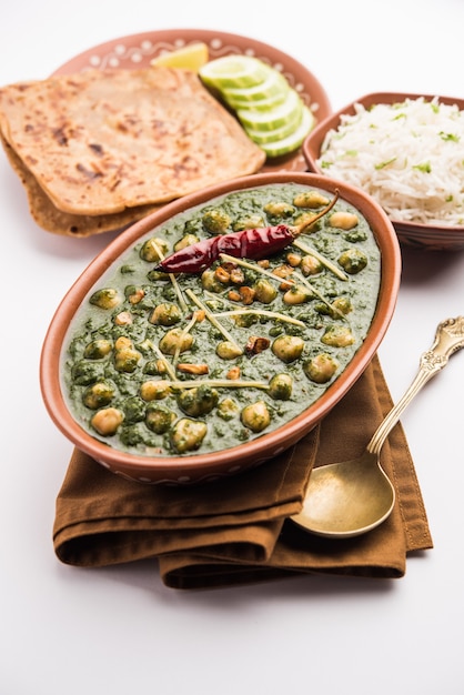 Curry di spinaci di ceci o Chana Masala con Palak servito con riso e focaccia o Paratha, fuoco selettivo