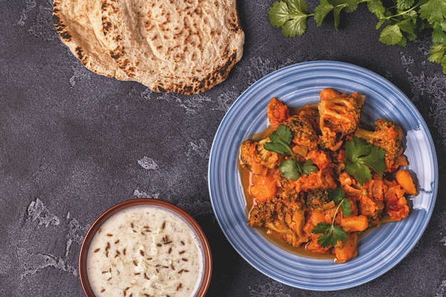 Curry indiano tradizionale con verdure e raita di pane