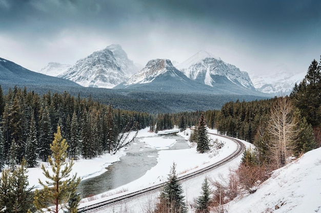 Curva di Morants con la ferrovia che passa attraverso la valle dell'arco e le montagne rocciose in inverno al parco nazionale di Banff