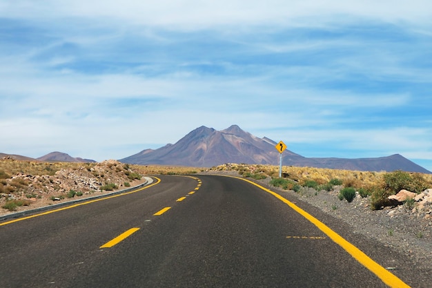 Curvy Road Signpost sulla strada del deserto vuoto nel deserto di Atacama del nord del Cile